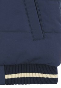 Giacca bomber blu navy con tessuto testurizzato diagonale, vita a coste con striscia bianca e finitura liscia con cuciture sottili.