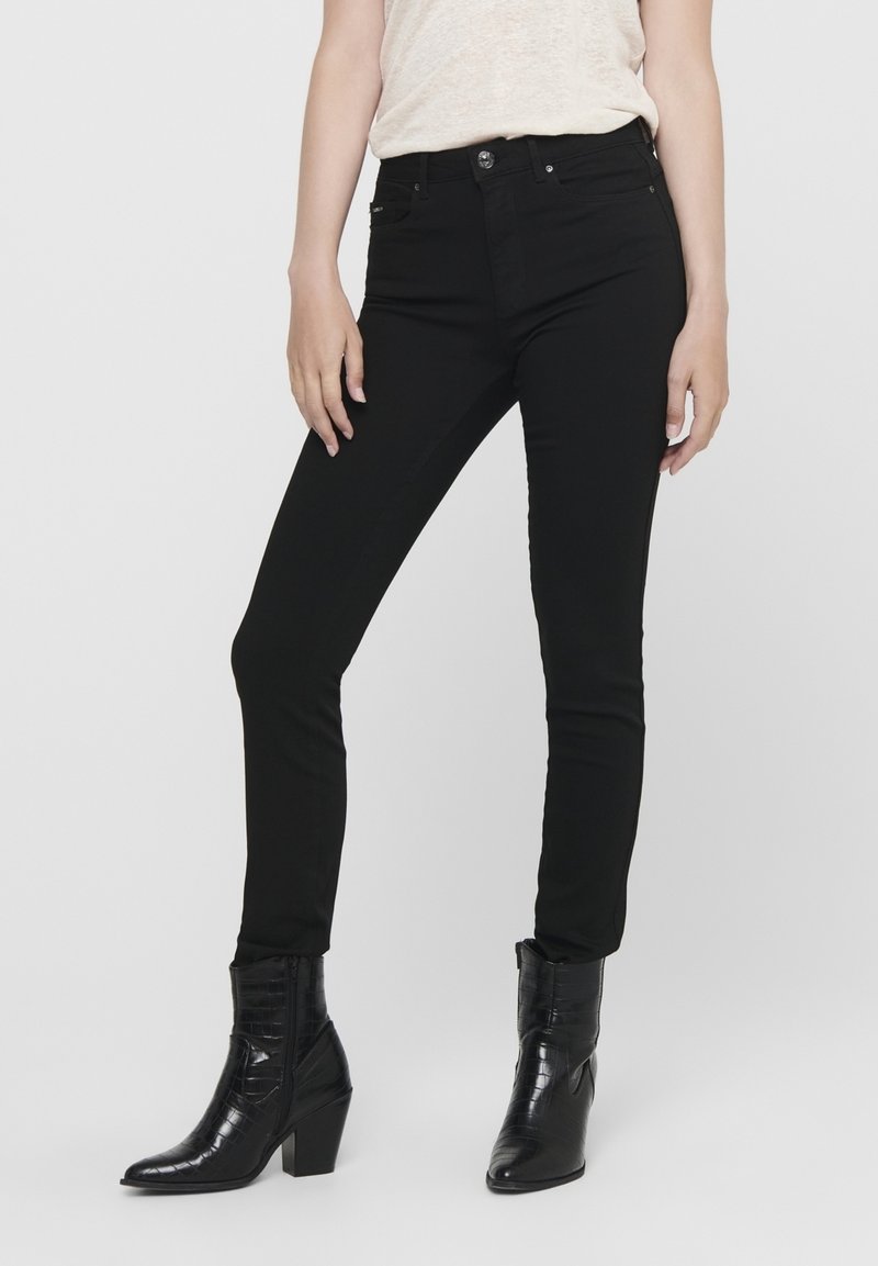 Svarta smala jeans med hög midja, tillverkade av denim. Har en framknäppning med knapp, fem fickor och en slät yta.