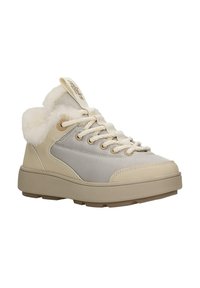 Beżowe trampki z chropowatą tkaniną na cholewce, futrzanym kołnierzem i masywną podeszwą. Z beżowymi sznurowadłami i metką z logo na języku.
