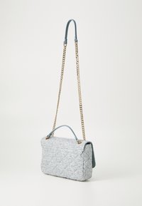 Quilted light blue tweed handbag with a soft handle, metal chain strap, and square shape. Features gold hardware and a textured surface.