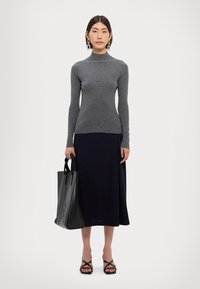Gray ribbed turtleneck sweater, black A-line skirt, black leather tote bag, and black strappy sandals. Smooth texture and fitted design.