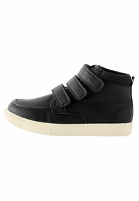 Chaussure haute en cuir noir avec trois bandes Velcro et une semelle en caoutchouc blanche. Présente une surface lisse et un design à bout rond.