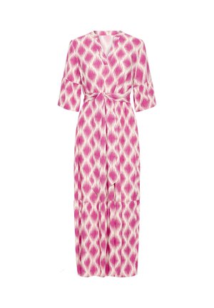 Midi šaty s ružovo-bielym vzorom, s rukávmi dĺžky po lakeť, výstrihom do V a opaskom previazaným v páse na jednoduchom pozadí.