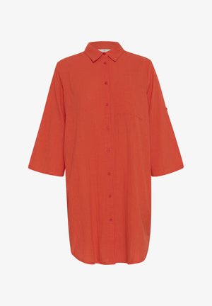 Sarkans krekls ar pogām, izgatavots no viegla auduma, ar apkakli, trīs ceturtdaļu piedurknēm un krūšu kabatu. Gluda tekstūra.