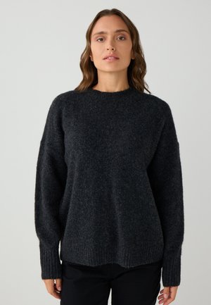 Maglione lavorato a maglia grigio scuro con scollatura rotonda, spalle scese, polsini a costine e tessuto texturizzato. Design semplice e dal taglio rilassato.
