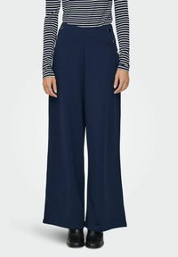 Navy wide-leg trousers made of soft fabric, featuring a high waist and decorative side buttons. Paired with a striped long-sleeve top.
