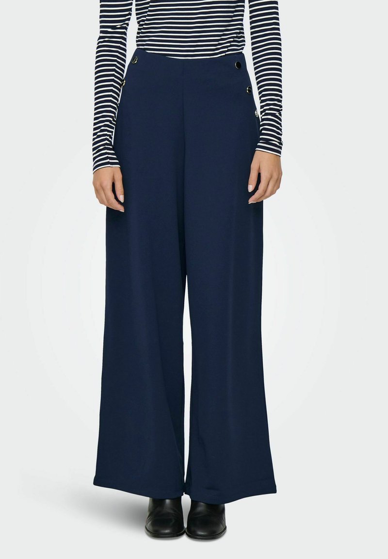 Navy wide-leg trousers made of soft fabric, featuring a high waist and decorative side buttons. Paired with a striped long-sleeve top.
