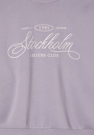 Liliowa bluza z białym nadrukiem tekstowym: "Północna Europa 1985 Klub Wypoczynkowy Sztokholm." Miękka tekstura z klasycznym wzorem okrągłego dekoltu.