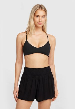 Zwart bikini topje met dunne bandjes en een V-hals, gecombineerd met zwarte gesmokte shorts met een losse pasvorm en geplooide textuur.