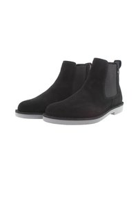 Botas de tobillo de ante negro con paneles laterales elásticos, punteras redondas y suelas de goma planas. Costura detallada a lo largo de la suela.