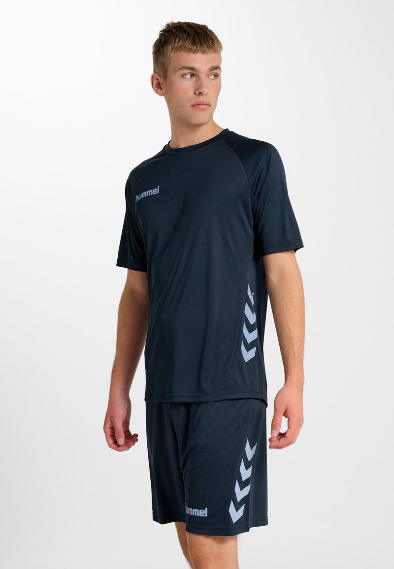 Granatowa koszulka sportowa z krótkim rękawem, z szarym logo i wzorem w kształcie chevronu po bokach, w zestawie z dopasowanymi granatowymi szortami, wykonana z oddychającego materiału.