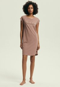 Krótka różowa nocna sukienka z rękawami w kształcie jajka, z białym nadrukiem tekstowym z przodu. Luźny krój z zaokrąglonym dołem.