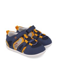 Zapatos infantiles de color azul marino con acentos naranjas, con un diseño de malla, tira de velcro y suela blanca. Ligeros y transpirables.