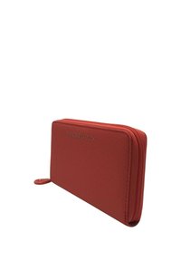 Portafoglio rosso con zip realizzato in materiale testurizzato. Presenta il logo sulla parte anteriore e una linguetta sul cursore della zip. Design slim e rettangolare.