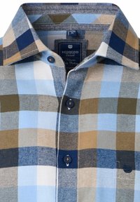 Plaid shirt featuring blue, tan, and green colors, button-down collar, blue buttons, and a tag labeled "REDMOND Casual." Soft cotton fabric.