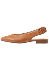Jasnobrązowe, płaskie buty typu slingback z kopertowym noskiem i marszczonym elastycznym paskiem, niski obcas, profil boczny na białym tle.