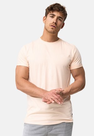 Helles rosa T-Shirt mit kurzen Ärmeln aus weicher Baumwolle, mit rundem Halsausschnitt und dezentem Logodetail auf der Brust. Lässige Passform.