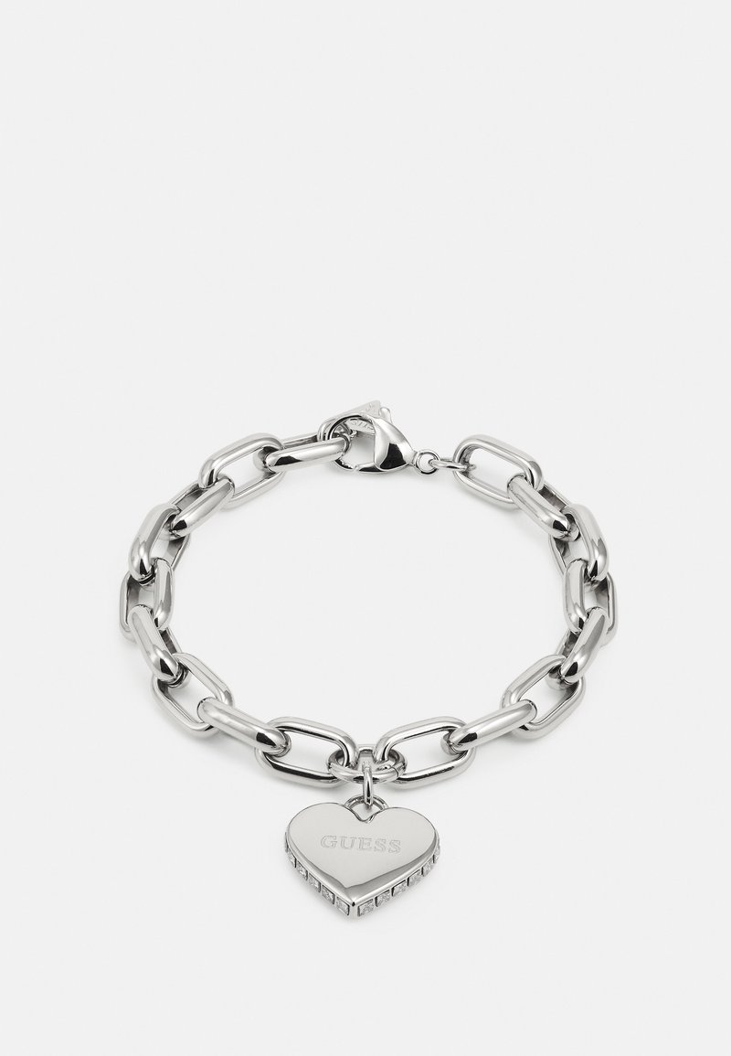 Silver chain bracelet featuring large links and a heart-shaped charm inscribed with "GUESS," embellished with rhinestones.