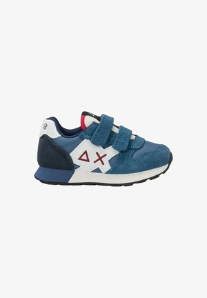 Sneaker per bambini blu e bianco con due strappi in velcro, disegni geometrici rossi sui lati e suola nera e bianca.