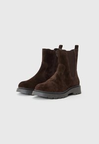 Bottines en daim marron avec une finition texturée, fermetures éclair latérales, panneaux élastiques et une semelle en caoutchouc épaisse. Comprend des orteils ronds et une languette.