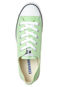 Grüne Leinensneaker mit weißen Schnürsenkeln, Gummizehenschutz und schwarzer Sohle. Mit Branding innen und außen. Glatte Textur.