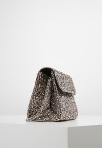 Błyszcząca torebka z metalowym łańcuszkiem, prostokątny kształt, klapa, powierzchnia pokryta wielokolorowymi cekinami.