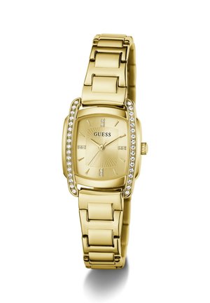 Montre-bracelet Guess ton or avec cadran rectangulaire, accents en cristal sur les côtés et index simples sur un cadran métallique.