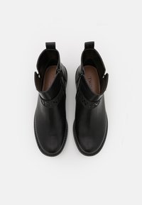 Černé kožené kotníkové boty s kulatou špičkou, bočním zipem a texturovaným páskem s embosovaným nápisem. Hladký povrch s plochou podrážkou.