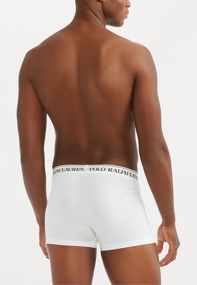 Weiße Baumwoll-Boxershorts mit einem schwarzen Logo-Bund, auf dem "Polo Ralph Lauren" steht. Glatte Textur, enganliegendes Design und Oberschenkel Länge.