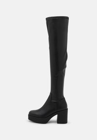 Botas negras por encima de la rodilla hechas de material sintético suave, con un tacón alto y grueso, y un diseño elegante sin hardware visible.
