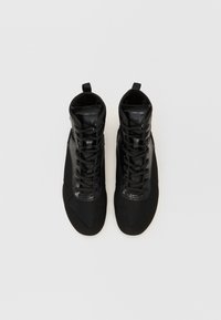 Sneaker alte nere con tomaia in rete strutturata, dettagli lucidi e lacci piatti; punta rinforzata e linguette per indossarli facilmente.