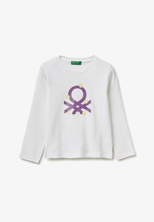 Biała koszula z długim rękawem z fioletowym geometrycznym symbolem i małymi żółtymi kwiatami nadrukowanymi z przodu, z okrągłym dekoltem.