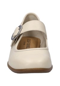 Zapato Mary Jane beige con punta redonda, correa ajustable y hebilla de plata. Parte superior de cuero suave, suela de goma plana con ligera textura.