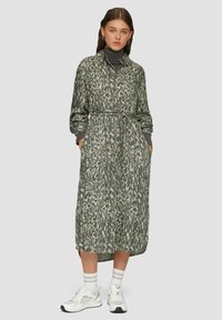 Nööbiga, pikkade varrukatega tume roheline kleit, millel on heledas rohelises abstraktne muster, vööga taljes, küljetaskudega ja vabalt langev lõige.