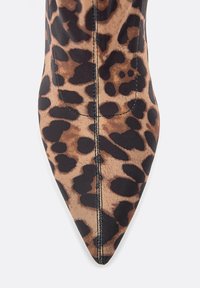 Bottine à talon haut en imprimé léopard avec un bout pointu, fabriquée en tissu lisse. Comprend des accents noirs et des coutures détaillées le long des seams.