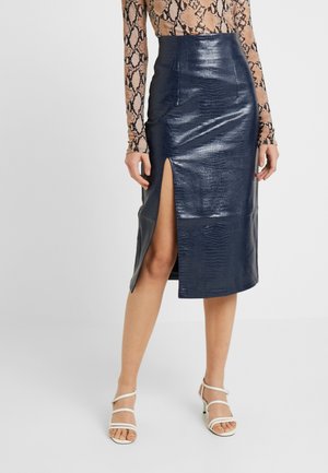 Granatowa spódnica ołówkowa z ekologicznej skóry, z wysokim stanem i bocznym rozcięciem; gładka faktura z delikatnym wzorem krokodyla.