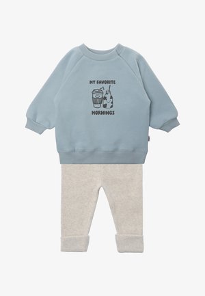 Hellblaues Sweatshirt mit langen Ärmeln und dem Text „My Favorite Mornings“ sowie Grafiken von Kaffee und Milchflasche, kombiniert mit hellbeigen Hosen.