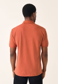 Poloshirt met korte mouwen in terracotta, met een klassieke kraag en een subtiele textuur, met een comfortabele pasvorm en een rechte zoom.