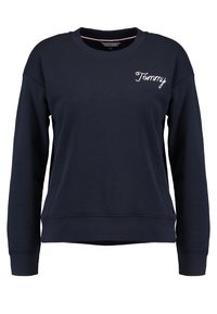 Sudadera azul marino hecha de tela suave, con cuello redondo, puños y dobladillo acanalados, y con "Tommy" bordado en blanco en el pecho.