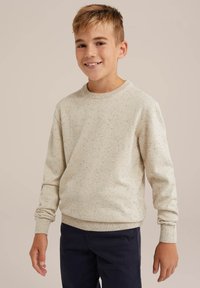 Beige sweatshirt med fläckig textur, rund halsringning och ribbade ärmslut, tillsammans med marinblå byxor. Avslappnad passform för komfort.