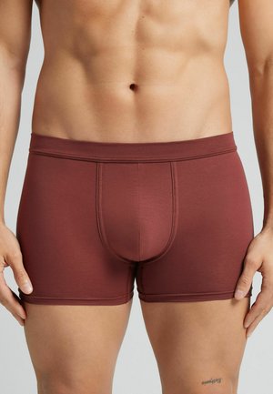 Boxer-briefs pour hommes en bordeaux, tissu extensible, design ajusté, texture lisse, taille mi-haute, avec une poche contour et des détails de couture.