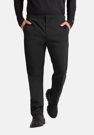 Schwarze, leichte Hose mit elastischem Bund, seitlichen Taschen, geradem Bein und glatter Oberfläche, kombiniert mit schwarzen Sportschuhen.