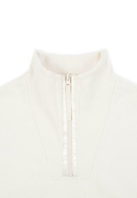 Quarter-zip tröja i krämfärgad ribbad tyg. Har en slät dragkedja med ett tygöverdrag vid kragen. Minimalistisk design.