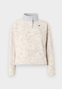 Fleece pullover in off-white with a textured surface, gray collar, snap closure, and small logo detail on the chest.