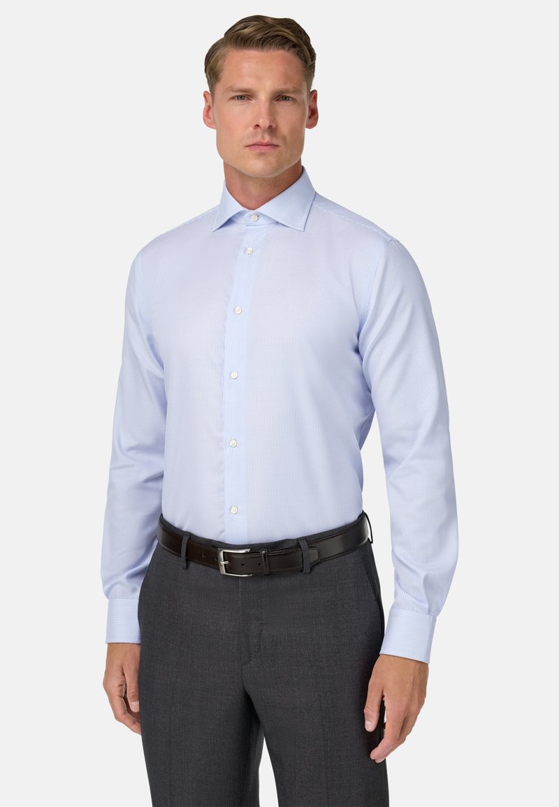 Lichtblauw geruit overhemd met een puntkraag, lange mouwen en een knoopsluiting, gecombineerd met donkergrijze broek en een zwarte riem.