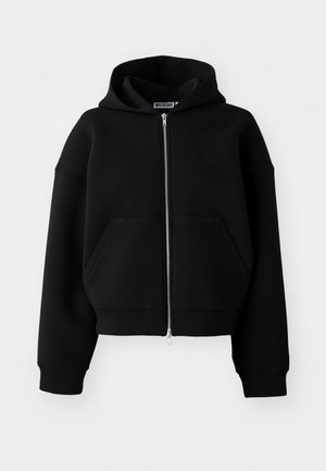 Black cropped hoodie made of soft fabric, featuring a front zipper, large front pockets, and a drawstring hood.