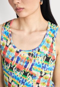Mehrfarbiges geripptes Tanktop mit runder Ausschnitt; zeichnet sich durch ein lebhaftes, abstraktes Muster in den Farben Rot, Blau, Grün und Gelb aus.