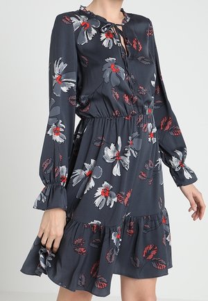 Sukienka z długim rękawem w ciemnym granacie z kwiatowym wzorem w kolorach czerwonym i szarym. Posiada falbaniany dół oraz dekolt z wycięciem i wiązaniami. Miła w dotyku, miękka tkanina.