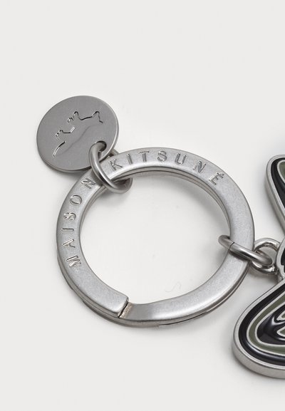  porte-clés en argent avec un anneau circulaire gravé "MAISON KITSUNÉ." Attachez un charme stylisé multicolore avec une texture lisse.