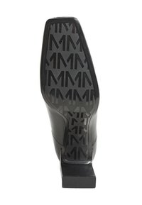 Suola di scarpa in pelle nera con un motivo testurizzato che presenta forme a "M" ripetute. Il design del tacco offre stabilità con una base piatta.